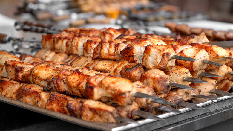 Pork kebabs stacked on a grill