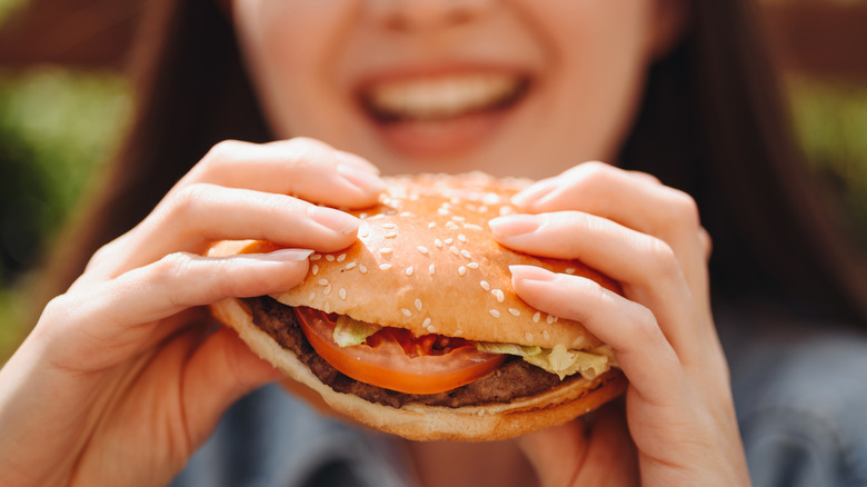 A woman eating a hamburger.