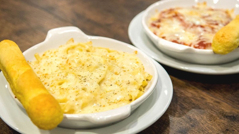 Pasta dishes with breadsticks on side