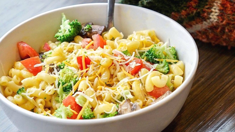 Person eating mac and cheese with veggies