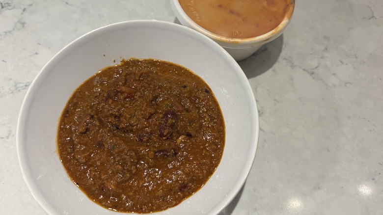 A bowl of Dave's Award-Winning Chili next to its original container from Famous Dave's
