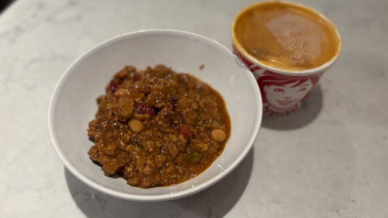 A bowl of chili from Wendy's next to its original packaging