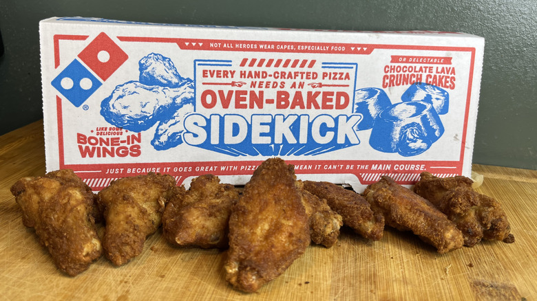 An 8 piece Dominos chicken wing order in front of the box