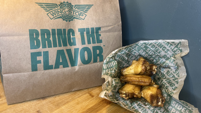 An order of plain wings from Wingstop in front of the bag