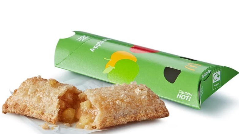 McDonald's apple pie broken in half with filling spilling out in front of the apple pie packaging