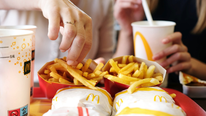 Tray of McDonald's food including fries, wrapped sandwiches, and drinks