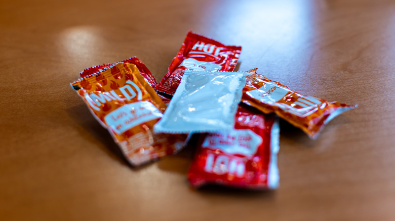 Taco Bell hot sauce packets on a wooden surface