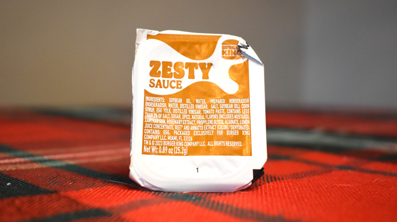 white and brown package of zesty sauce