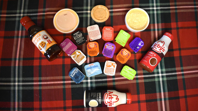 Fast food sauces spread out on a red tablecloth