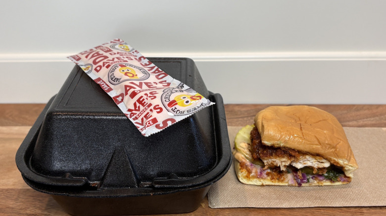 Dave's Hot Chicken Slider Half on napkin next to box and hot sauce packet