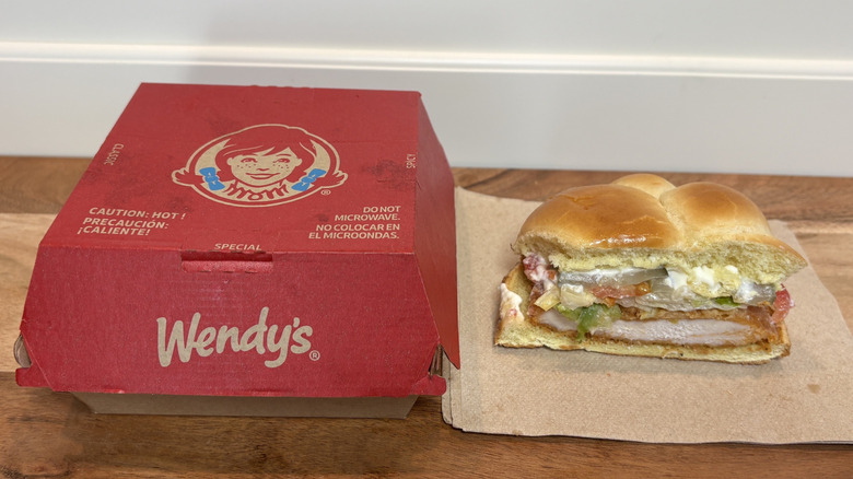 Wendy's Spicy Chicken Sandwich half on napkin next to Wendy's box