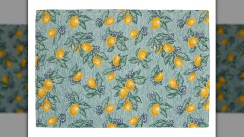 Rectangular green floor mat with a lemon pattern on a green background.
