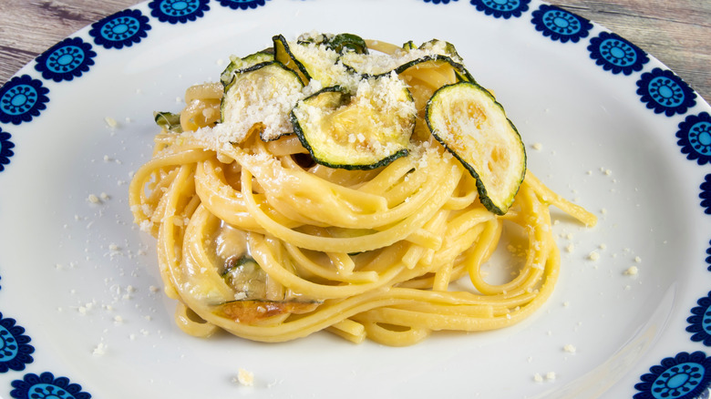 closeup of the pasta with a zucchini coins and cheese on top