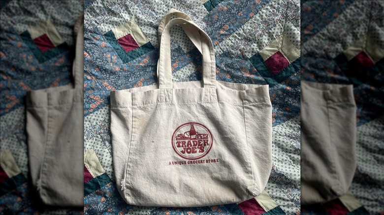 A simple Trader Joe's canvas tote on a quilt