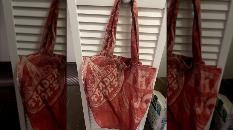 A vintage red bag from Trader Joe's hanging on a door knob