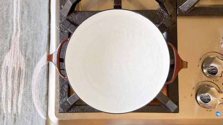 Brown pot of water simmering on stovetop