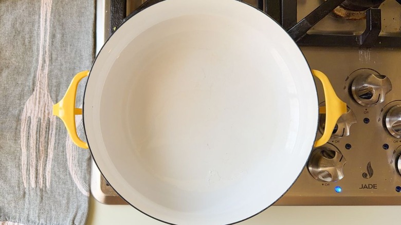 Coconut oil heating in large yellow pot on stovetop