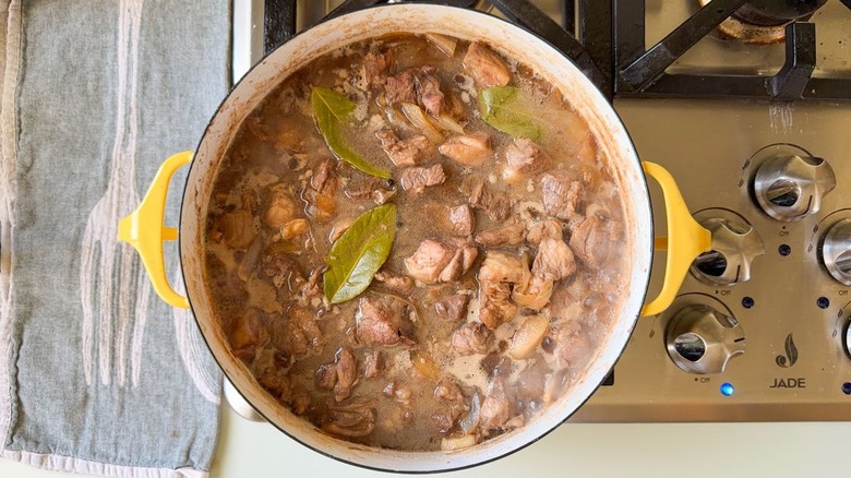 Filipino pork adobo cooking in large pot on stovetop