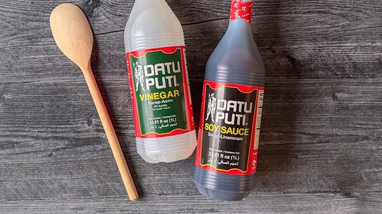 Datu Puti brand Filipino cane vinegar and soy sauce in bottles on countertop with wooden spoon