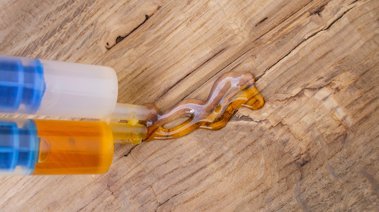 Two part epoxy is squirted on a wooden counter