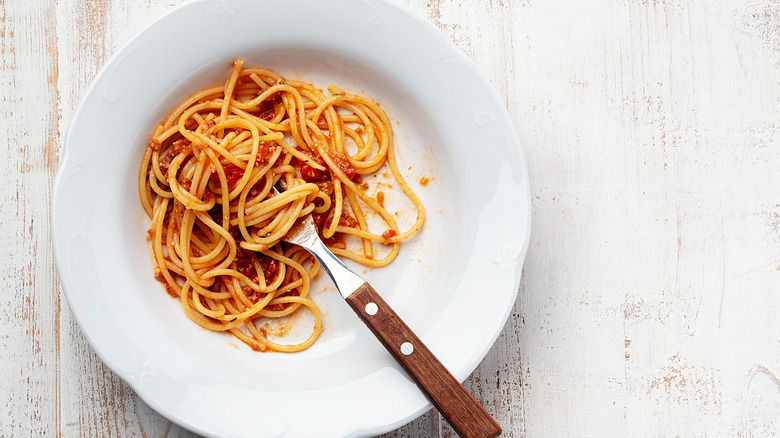 Half finished plate of spaghetti with a fork