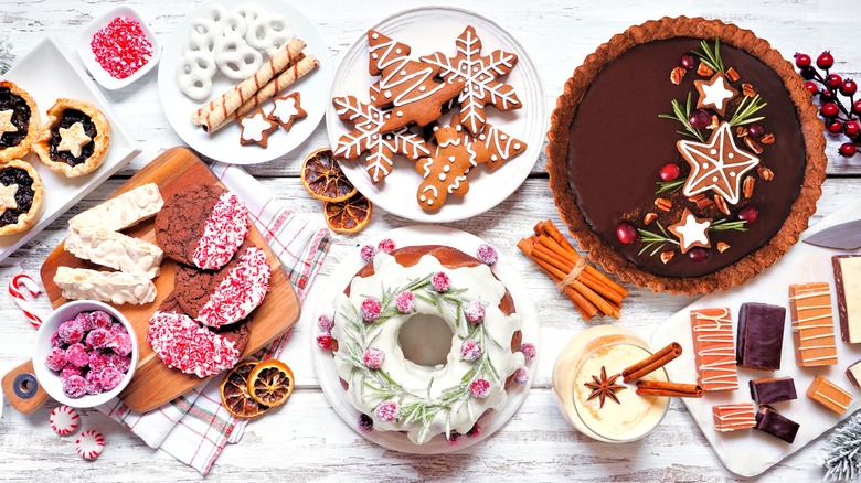 an assortment of classic holiday desserts, including cookies, cakes, pies, and eggnog