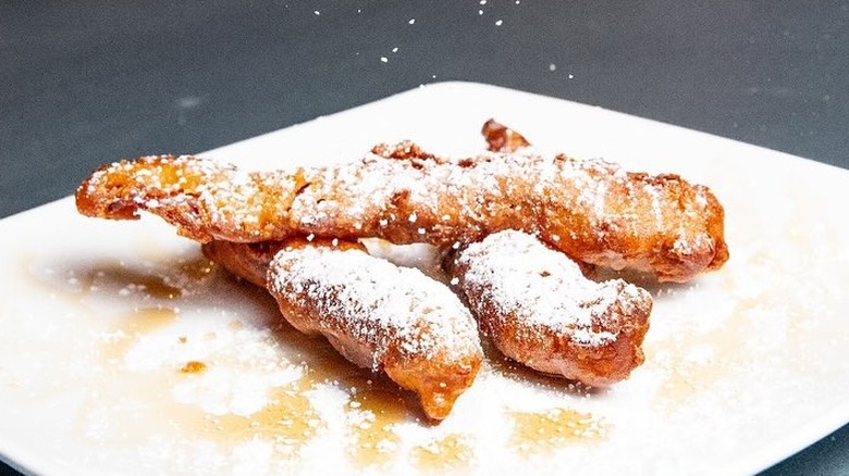 Pancake-battered bacon dusted with powdered sugar