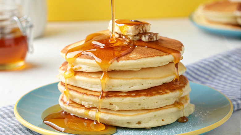 Stack of buttermilk pancakes drizzled with syrup