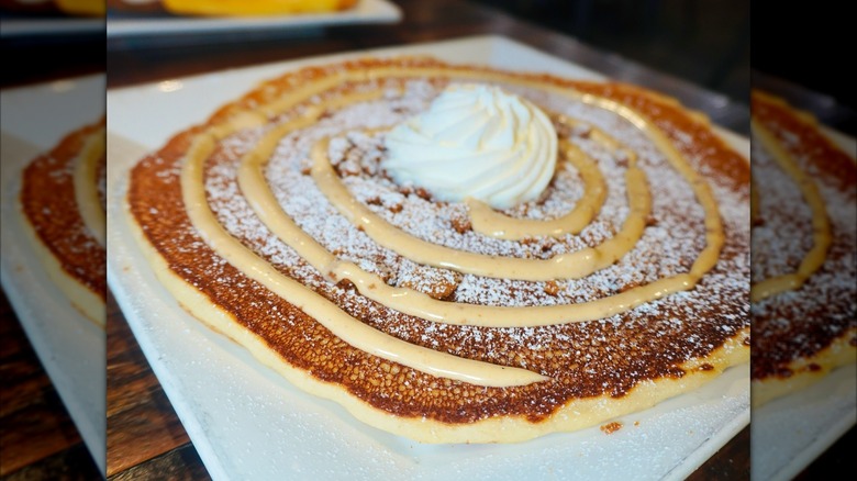 Large pancake topped with swirl of cream