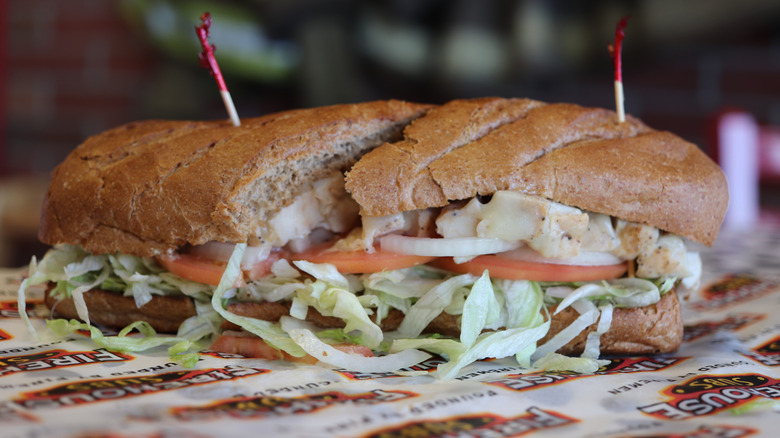 A Firehouse Subs sandwich loaded up with chicken, lettuce, tomato, onion, and melted cheese