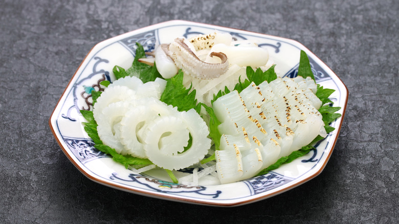 cuttlefish sashimi laid out on a plate with shiso leaves