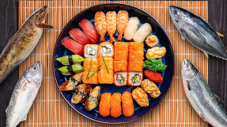 assortment of various sushi surrounded by raw fish