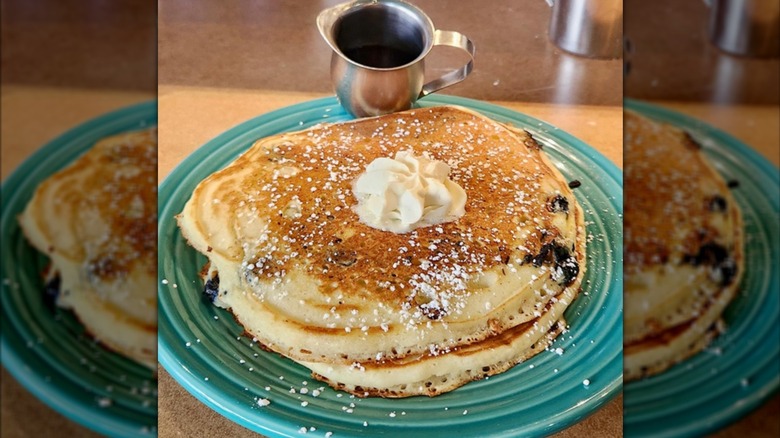 A stack of pancakes with butter on a blue plate at Geraldine's Counter in Seattle.