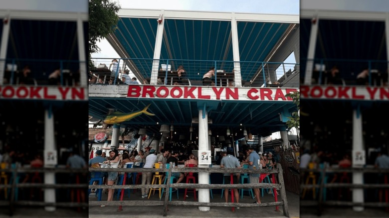 People are seen dining in the sunshine at Brooklyn Crab.