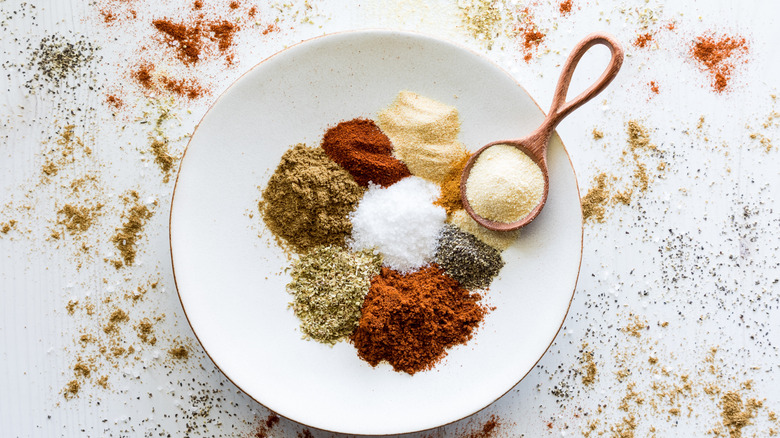 blend of spices on a white plate with a small wooden spoon