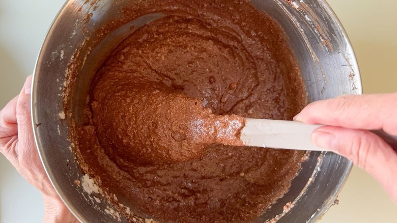 Gianduja chocolate cake batter in mixer bowl with spatula