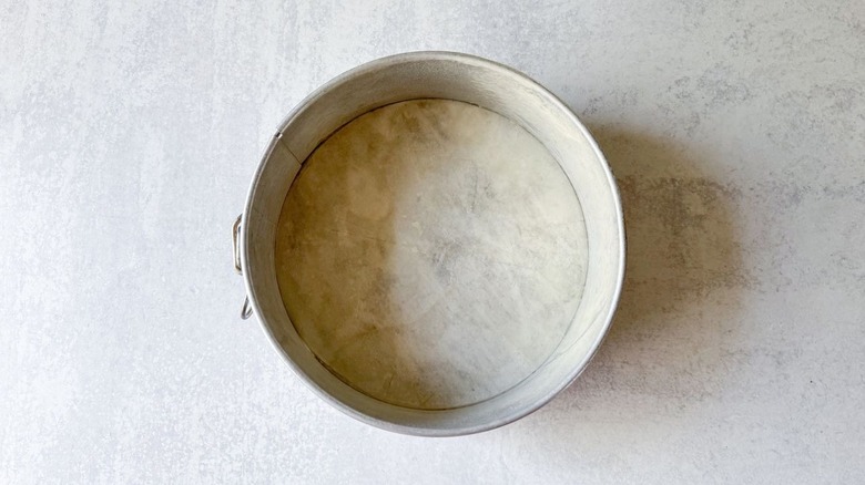 Springform pan with parchment circle on countertop