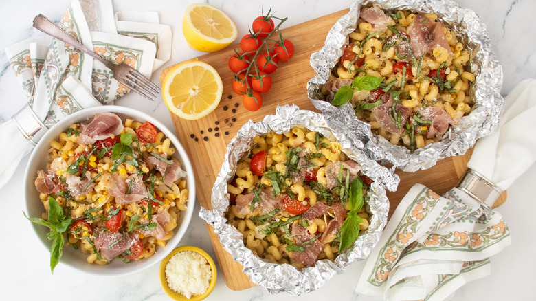 Overhead shot of a bowl filled with pasta and a foil pouches of pasta