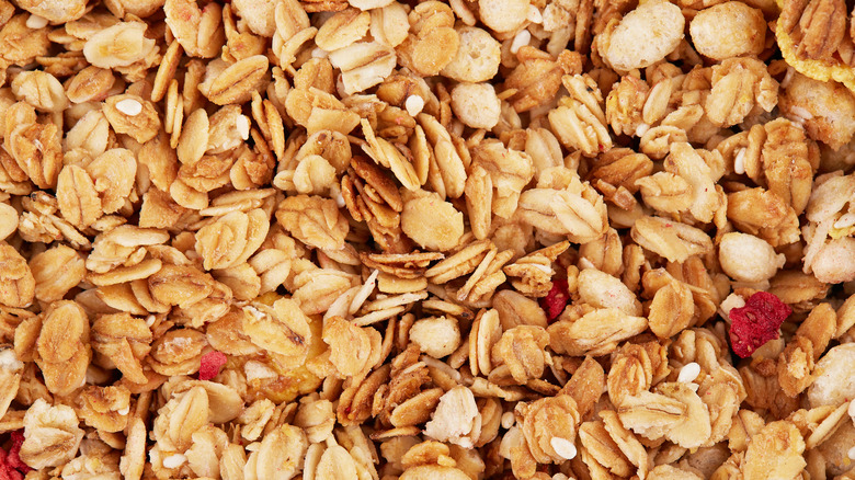 A close-up of granola sprinkled with pieces of dried fruits