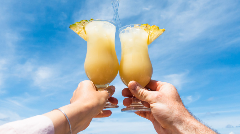 Hands holding piña coladas