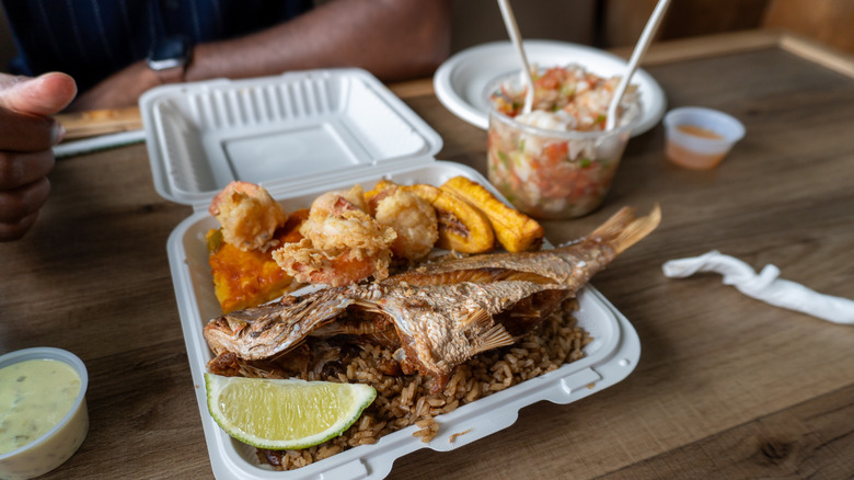 Plate of fried fish dinner with plantains and lime