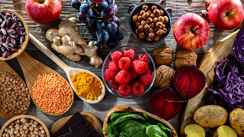 Board containing antioxidant-rich foods, including raspberries, spinach, apples, red grapes, and ginger