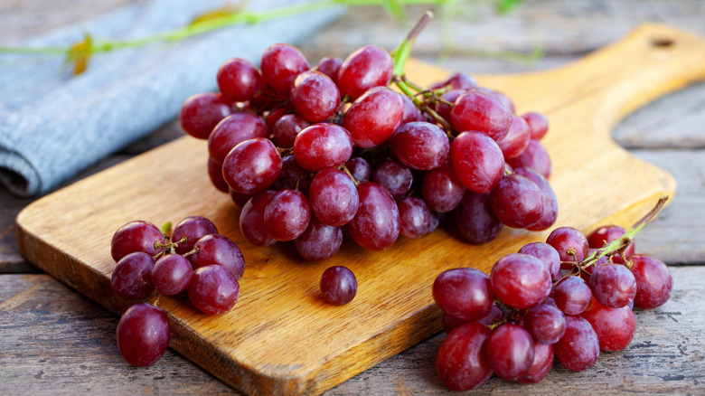 Red grapes on a wooden cutting board