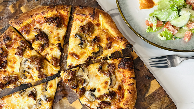 Homemade pizza sliced on cutting board