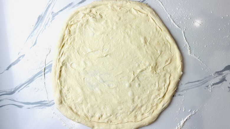 Stretched pizza dough on table