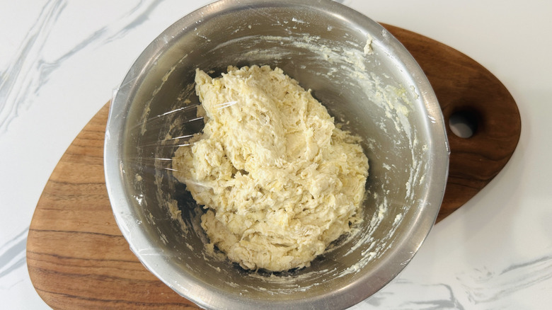 Covered pizza dough in bowl