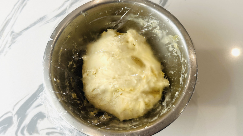 Covered pizza dough in bowl