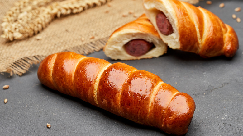 Pretzel dogs with a golden brown sheen on a surface