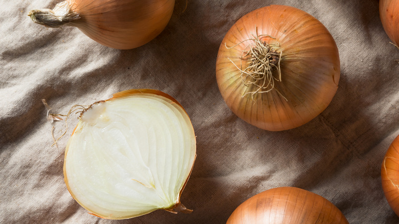 Yellow onions on a piece of cloth.