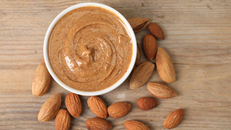 Almond butter in a bowl with almonds on the side